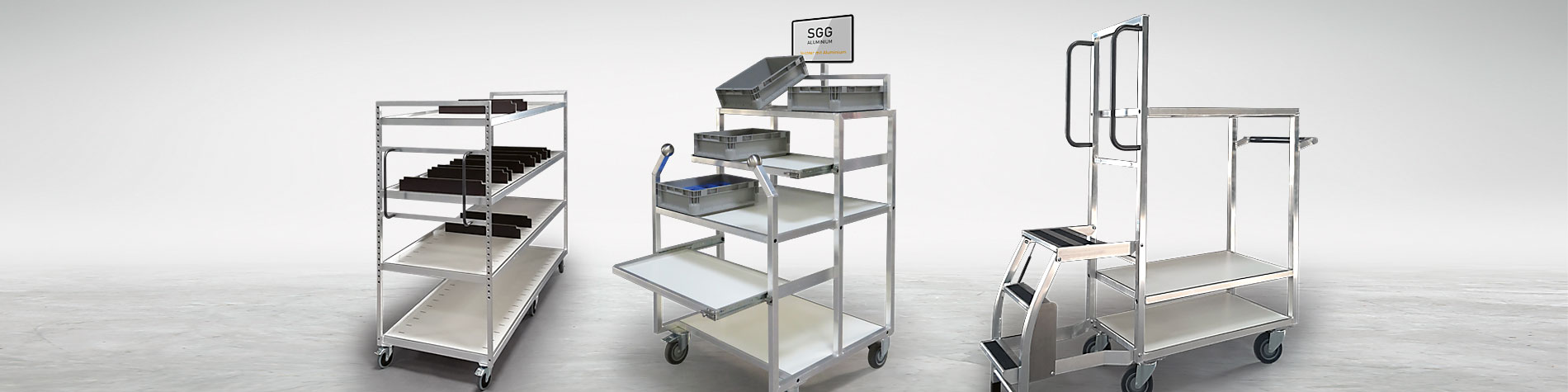 Zusammenstellung von drei Kommissionierwagen aus Aluminium, die vor einem grauen Hintergrund präsentiert werden