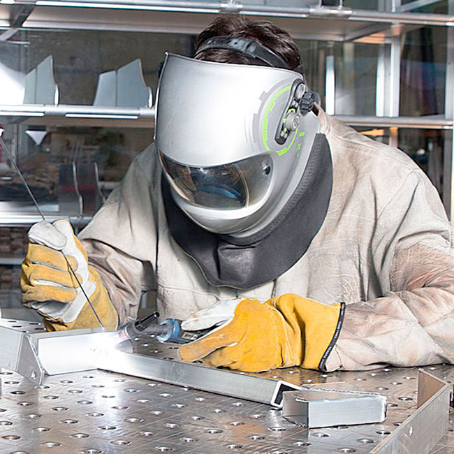 Ein Mitarbeiter von SGG Aluminium schweißt Bauteile aus Aluminium